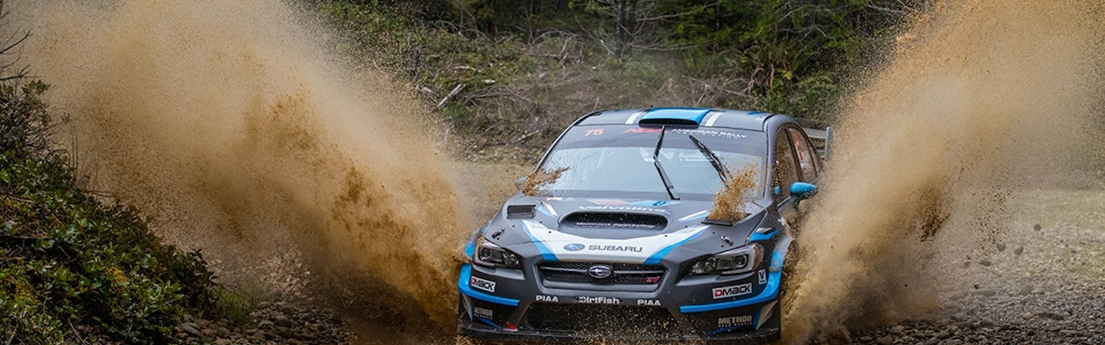 David_Higgins_powers_through_standing_water_on_the_course_at_the_Olympus_Rally_UW3A5759-2